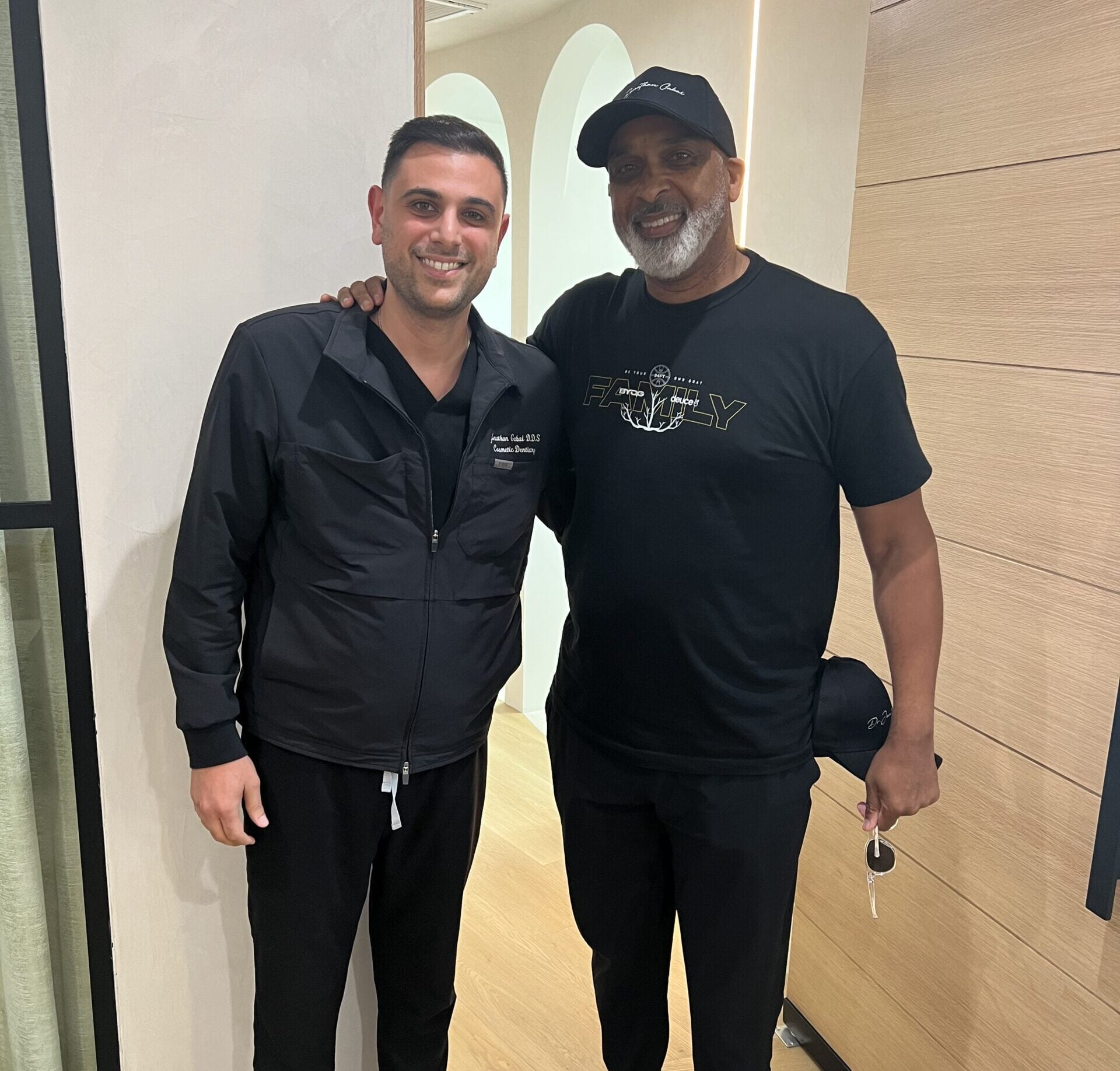 Dr. Jonathan Gabai with patient after treatment – Dental Implants Smiling dentist Dr. Jonathan Gabai standing with a happy patient inside the dental office, showcasing restored confidence after dental implants – Dental Implants