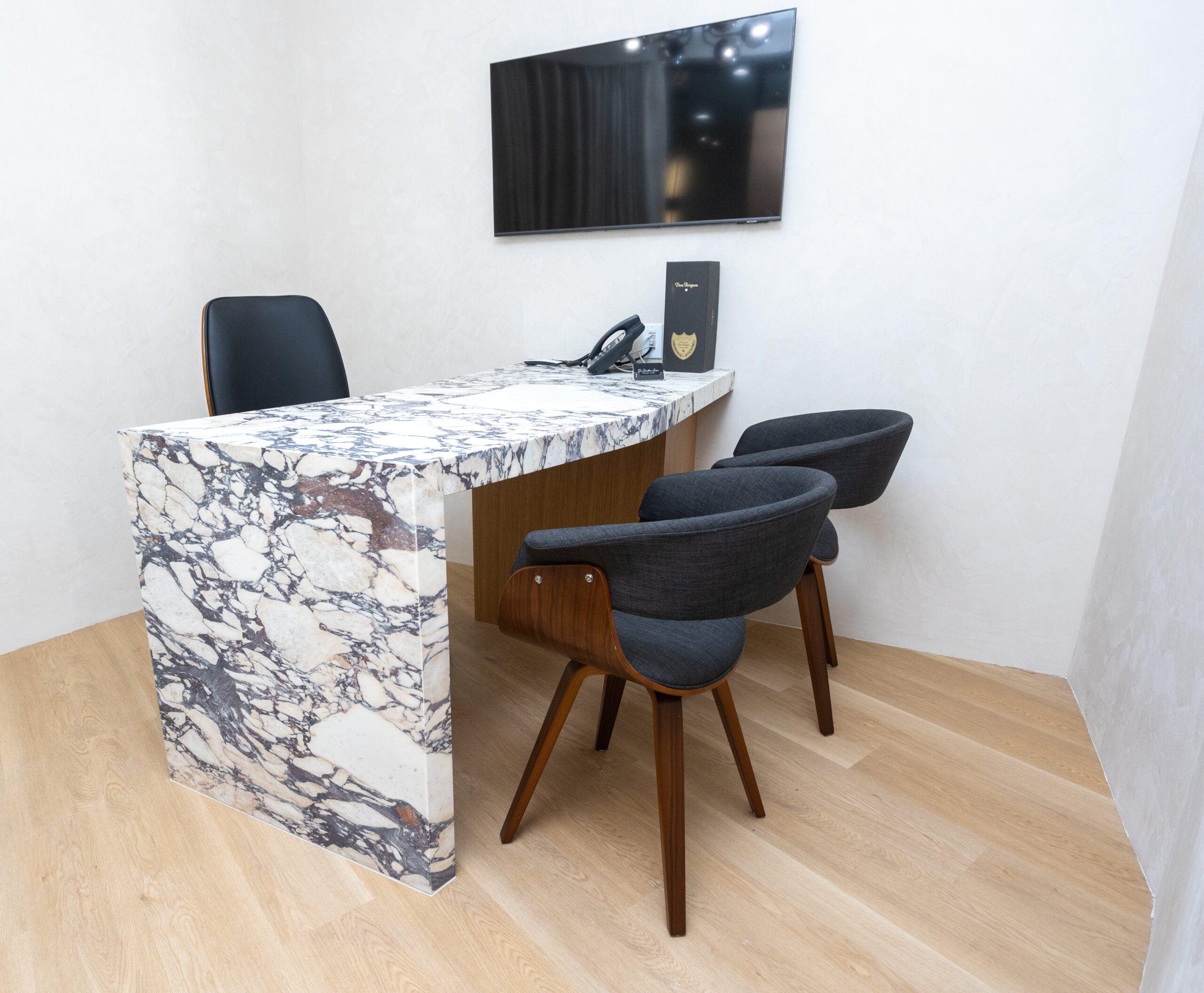 Dental consultation office with marble desk and seating A private consultation room with a marble desk, chairs, and TV screen, designed for patient discussions